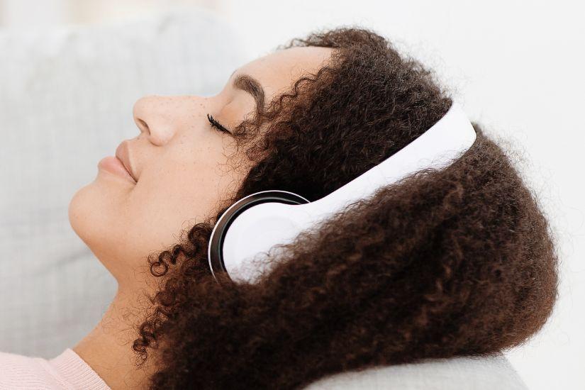 Schaffe Raum für dich selbst. Eine Frau, die mit Kopfhörern entspannt Musik hört.