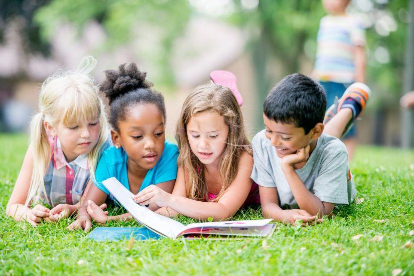 Ein perfekter Sonntag kann auch eine Zeit sein, in der du lernen und dich persönlich weiterentwickeln kannst. 4 Kinder, die gemeinsam lesen.