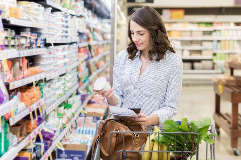 Es mag vielleicht unsexy klingen, aber ja, du kannst bei Lebensmitteln viel und sogar schnell Geld sparen, ohne auf Genuss zu verzichten. Frau beim Lebensmittel einkaufen.