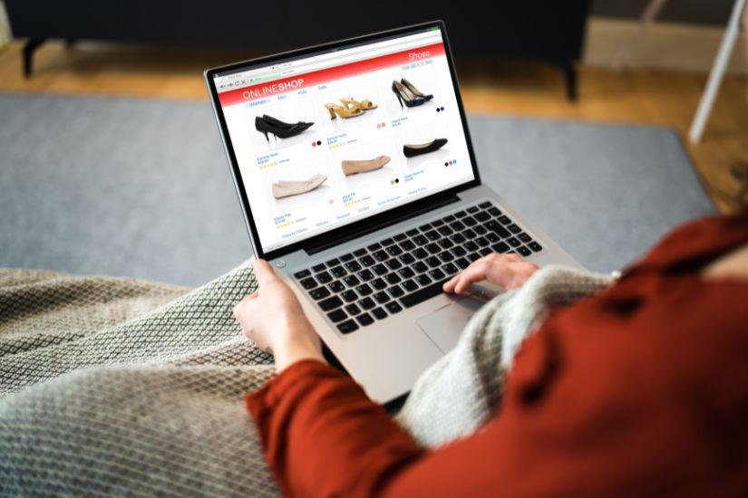 Einer der größten Geldfresser sind Impulskäufe, die dein Budget schnell sprengen können. Frau beim Online-Shopping