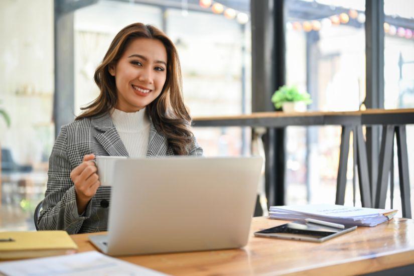 Worum soll es in deinem Online-Business gehen? Frau, fröhlich am Laptop sitzend