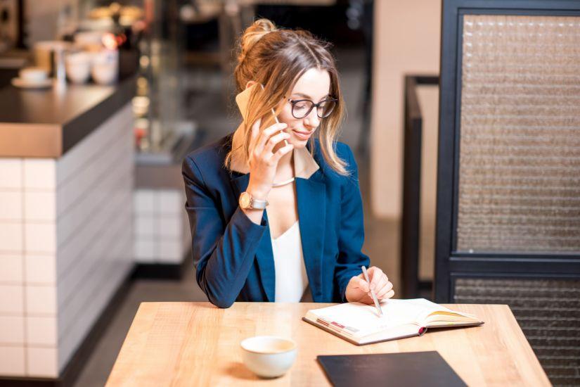 Ich weiß, dein Alltag ist vollgepackt. Deshalb habe ich ein paar Tipps für dich, wie du die Arbeit an deinem Money Mindset ganz einfach in deinen Alltag integrieren kannst. Frau, die am Morgen einen Kaffee trinkt und dabei in einen Kalender schaut.