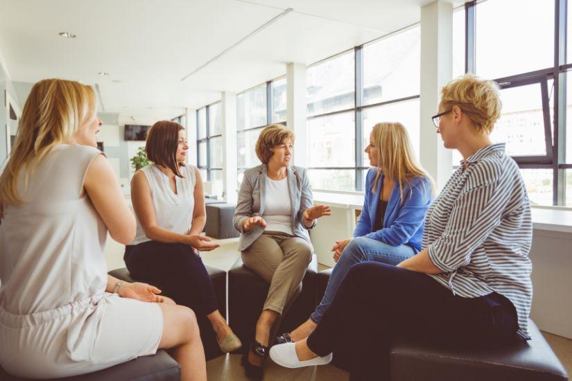 Unterschätze nicht den Einfluss der Menschen um dich herum auf deine finanziellen Gewohnheiten und dein Money Mindset. Eine Gruppe von Frauen, die in einer Diskussion, gemeinsam über Geldthemen sprechen.