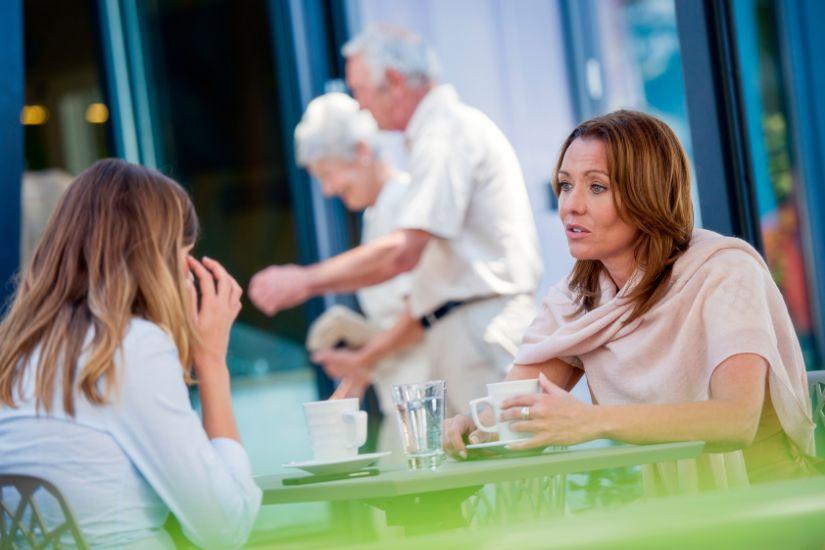 Austausch mit anderen kann unglaublich motivierend sein.  Zwei Frauen, die sich in einem Café beraten.